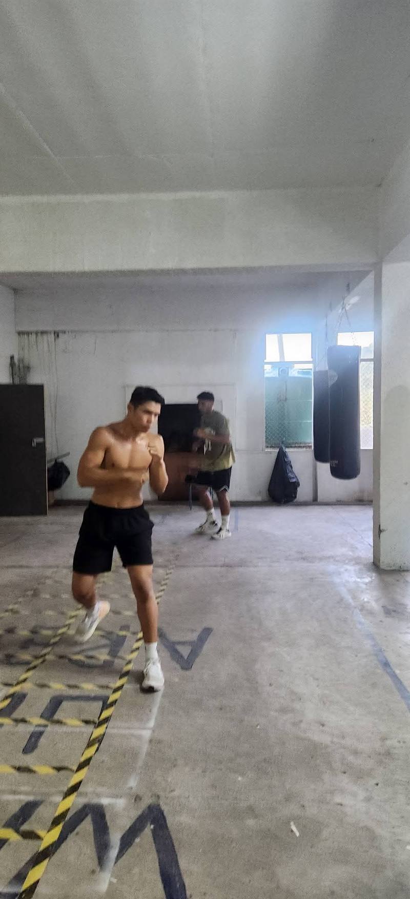 Two boxers shadowboxing on the agility-ladder floor