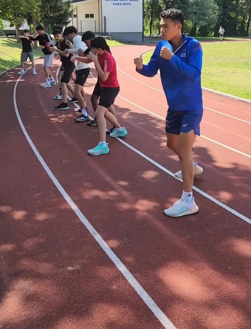 SUBA boxer leading shadowboxing drills on a running track with international boxers